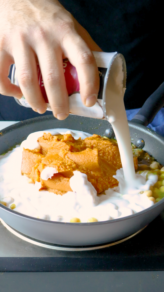 Next, add in chickpeas, coconut milk, pumpkin purée, and water. 